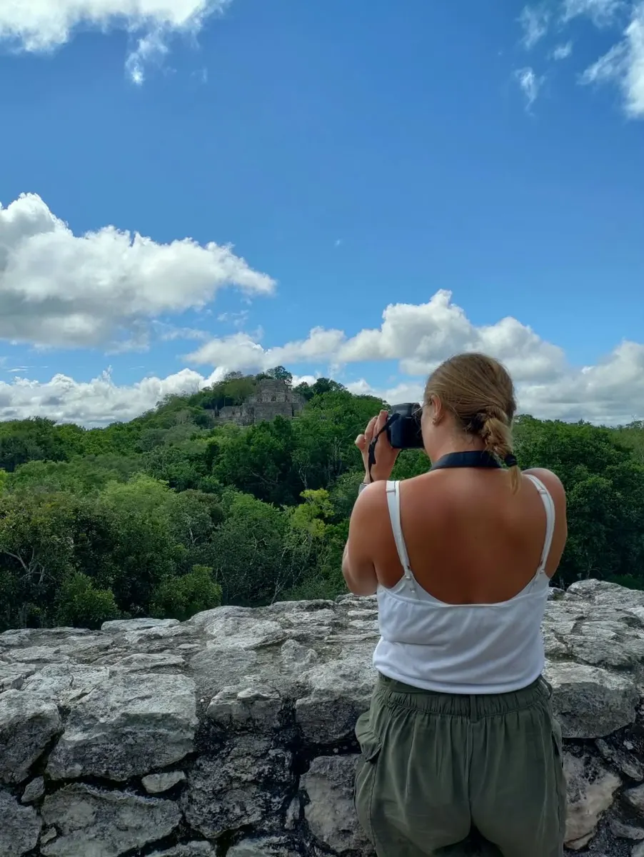 Viajera fotografiando la pirámide de Calakmul entre la selva